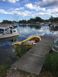 Sailboats moored on lake against sky