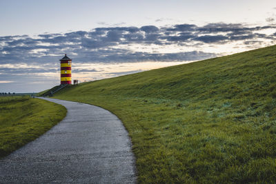 Road leading towards lighthouse against sky