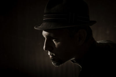 Portrait of young man against black background