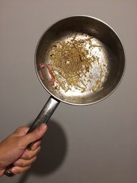 Cropped hand holding pan with leftovers