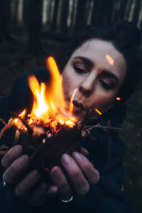 Close-up portrait of woman burning fire