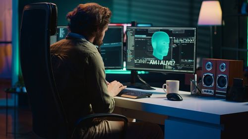 Rear view of man using laptop on table