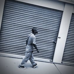 Full length rear view of man walking against building