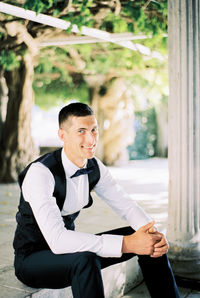 Young man looking away while standing outdoors