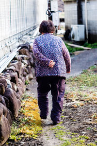 Rear view of man walking on road in city