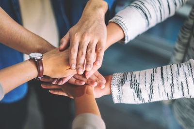 Midsection of business people stacking hands