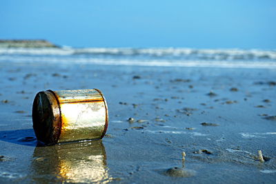 Close-up of bottle on beach
