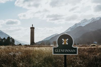 View of road sign against cloudy sky