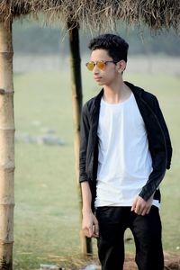 Teenage boy wearing sunglasses while standing on field