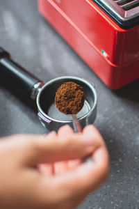 Cropped image of man pouring coffee in portafilter