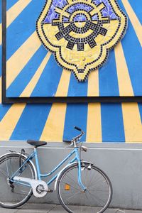 Bicycle parked against blue wall
