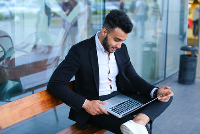 Side view of businessman using laptop at office