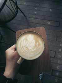 Waitress serving cappuccino on cafe tray