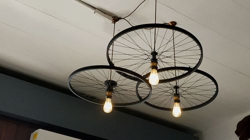 Low angle view of illuminated pendant light hanging on ceiling