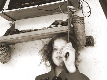 Portrait of young woman looking away against wall