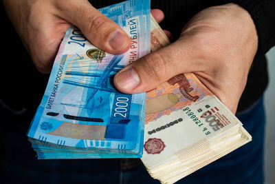 Hands close-up holding two bundles of russian money, two thousandth and five thousandth bills