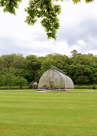 House on field against sky, greenhouse of glass in ireland 