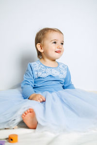 Cute baby girl in blue princess dress playing with toys at home. kids dresses for prom and birthday