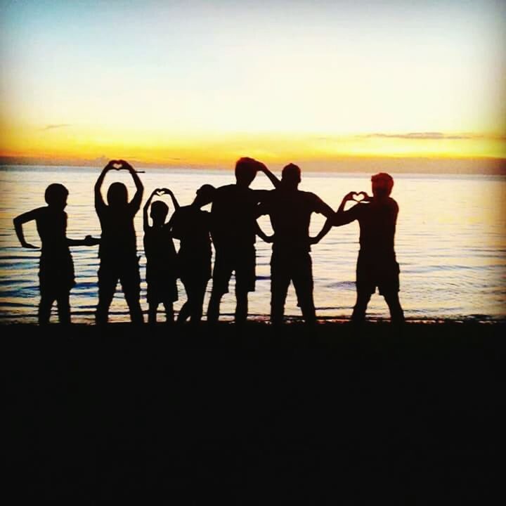 SILHOUETTE PEOPLE STANDING AT BEACH DURING SUNSET