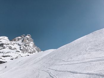 Snowcapped mountains against clear blue sky