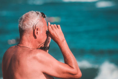 Midsection of shirtless man in sea