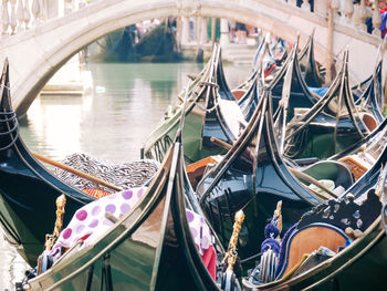 Group of traditional gondolas moored on narrow canal in venice