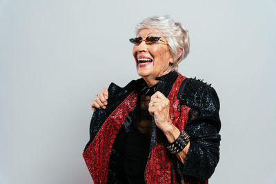 Portrait of young woman standing against white background