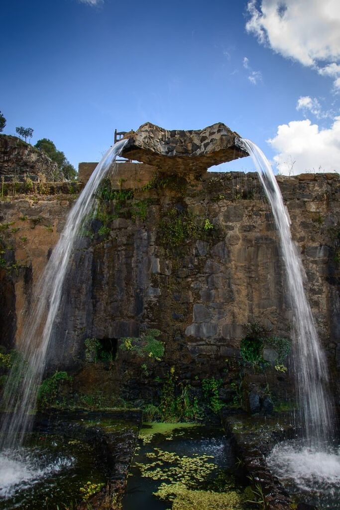 water, rock - object, rock formation, motion, waterfall, flowing water, scenics, beauty in nature, long exposure, sky, splashing, nature, cliff, low angle view, power in nature, surf, flowing, rock, travel destinations, famous place