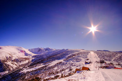 Scenic view of snowcapped mountains against blue sky