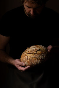 Midsection of man holding bread