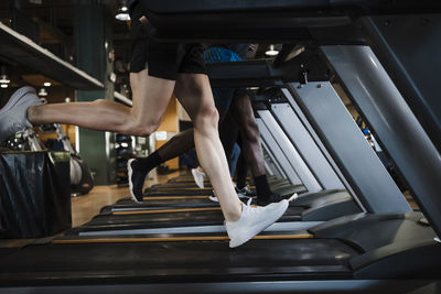 Sports people running together on treadmill in health club