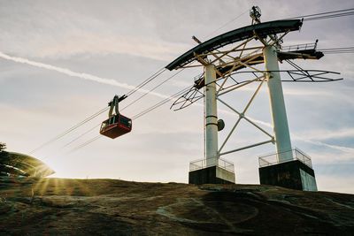 Low angle view of overhead cable car against sky