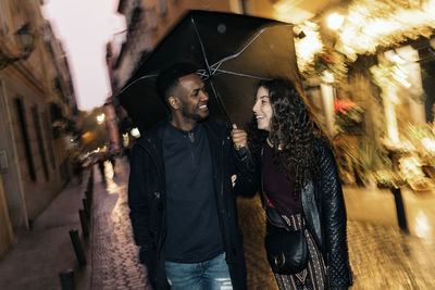 Young woman on street in illuminated city at night