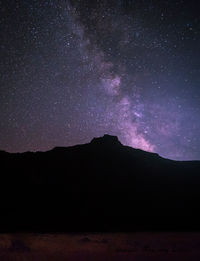 Scenic view of silhouette mountains against sky at night