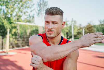 Portrait of smiling young man exercising in park