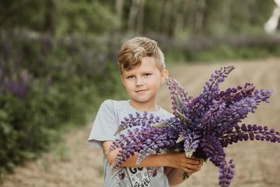 Portrait of boy holding lavender flowers