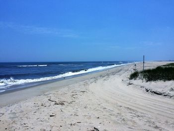 Scenic view of beach against blue sky