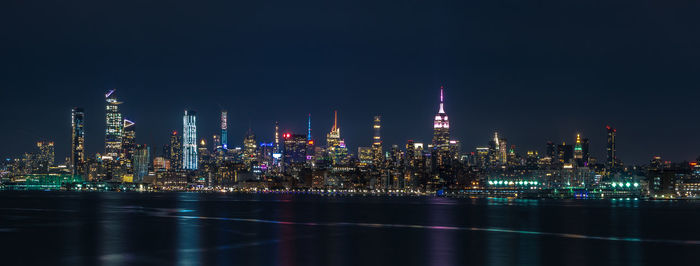 Illuminated buildings against sky at night