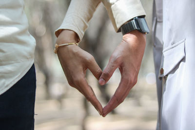 Midsection of couple holding hands