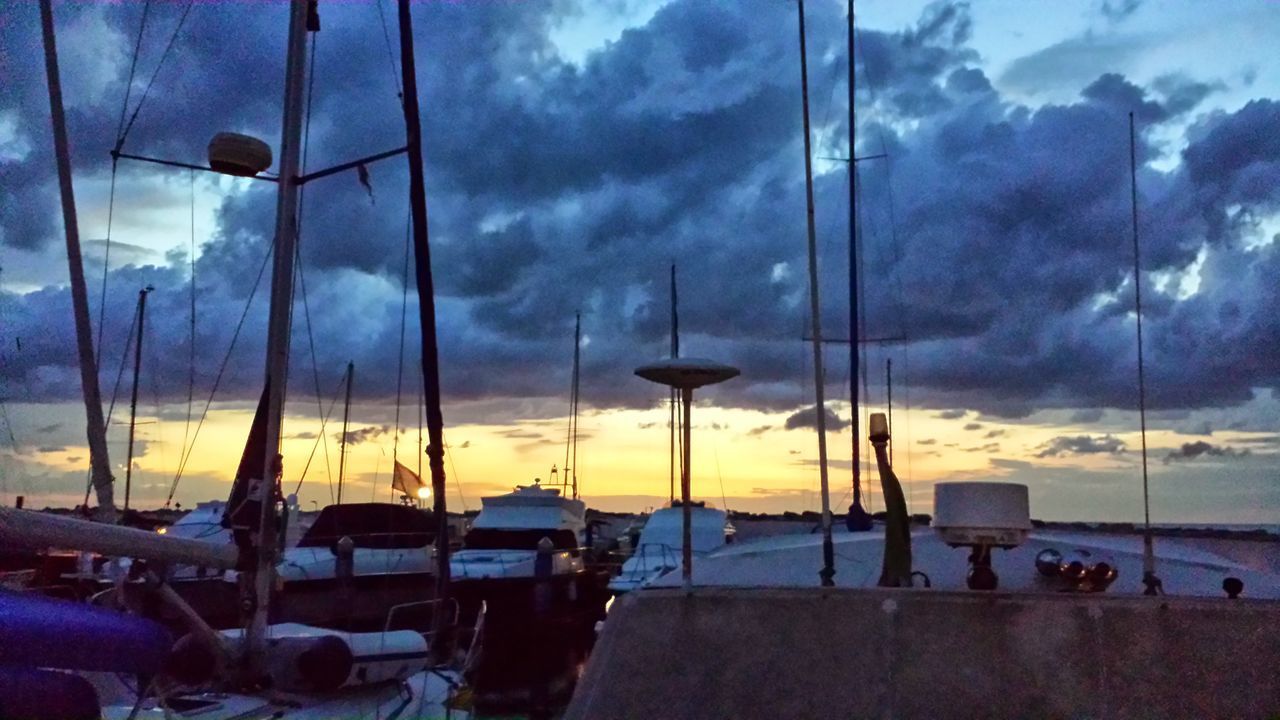 BOATS MOORED IN SEA AGAINST SKY