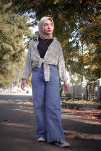 Portrait of woman standing on road in city