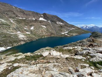 Scenic view of lake and mountains against blue sky