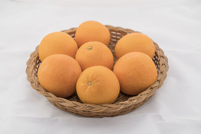 High angle view of fruits in basket on white background