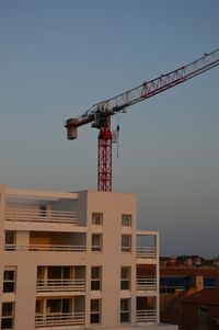 Low angle view of crane against clear sky