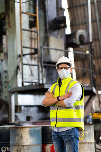 Man holding umbrella while standing at construction site