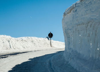 Rear view of man walking on snow covered landscape