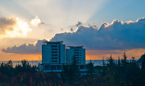 Buildings against cloudy sky at sunset