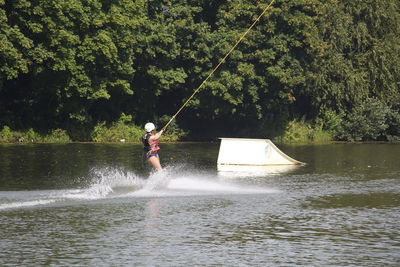 Man in boat on lake against trees