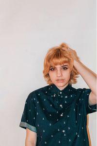 Portrait of young woman standing against white background
