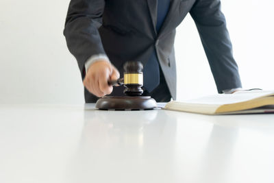 Midsection of man reading book on table